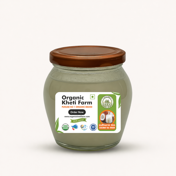 Bottle of organic cold pressed virgin coconut oil with fresh coconuts from Punjab farm