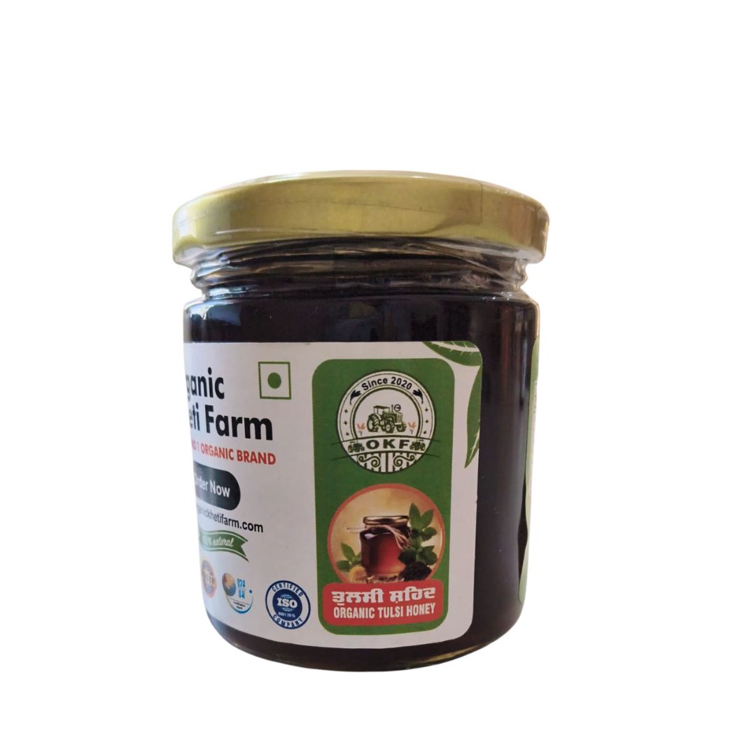 Close-up of a jar of organic Tulsi honey with fresh tulsi leaves on a rustic wooden table, highlighting purity and natural origin