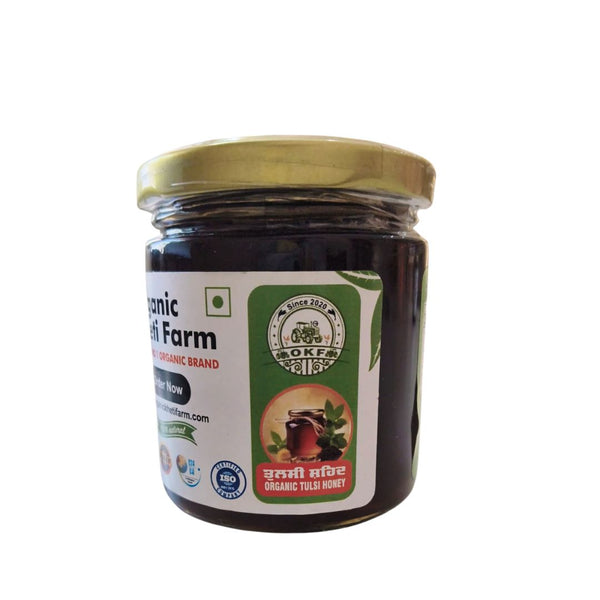 Close-up of a jar of organic Tulsi honey with fresh tulsi leaves on a rustic wooden table, highlighting purity and natural origin